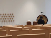 an empty room with wooden benches and a mirror